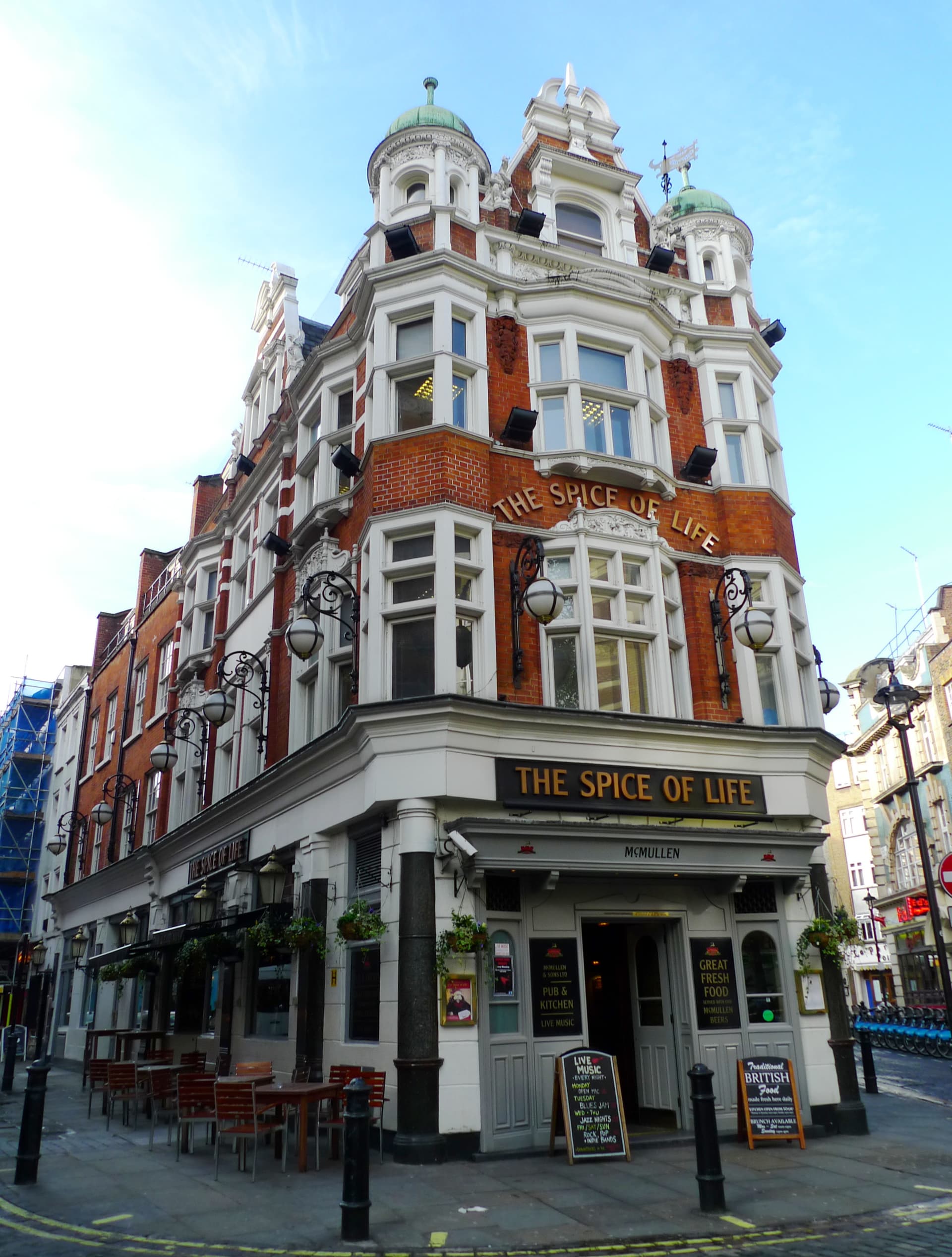 Red-brick and white Victorian corner pub with domed turrets, The Spice of Life, under a clear blue sky